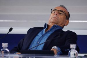 Carlo Conti si stende all'indietro su una sedia